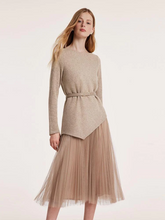 a lady in asymmetrical hem top and tulle midi skirt with belt